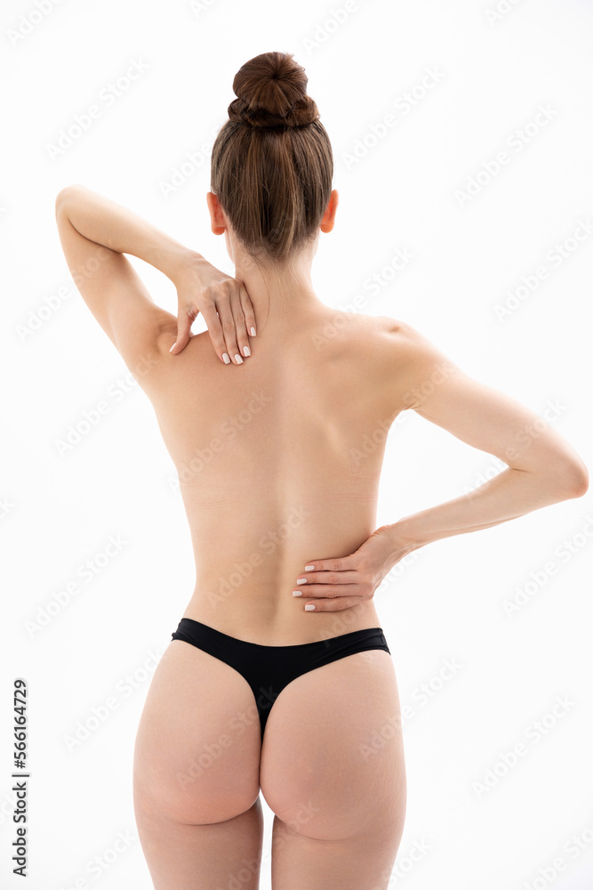 Young woman touches and rubs her back. Back problems. Back pain. Young woman touches and rubs her back. Back problems. Back pain.