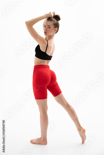 Slim sporty fitness young woman in black top and red leggings