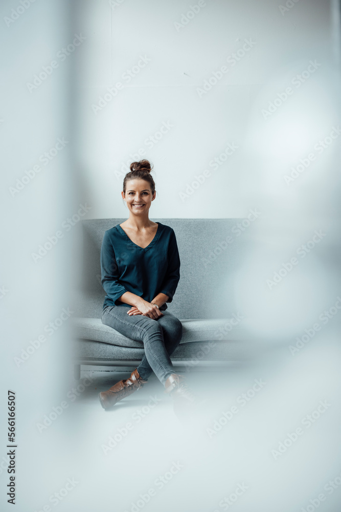 Happy businesswoman sitting on sofa at home office Happy businesswoman sitting on sofa at home office