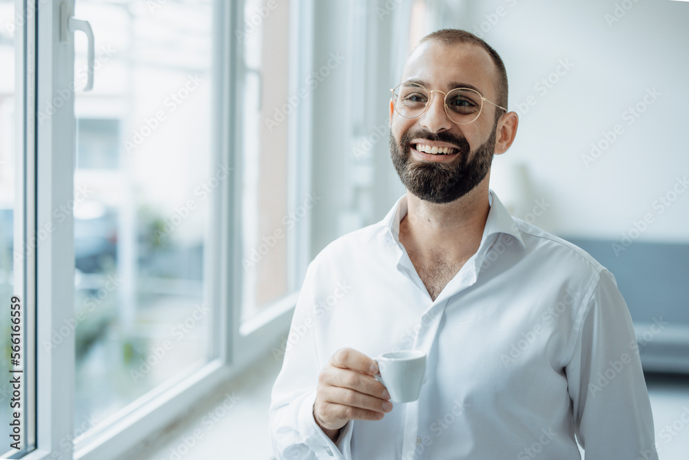 Happy businessman with cup of coffee standing at home office Happy businessman with cup of coffee standing at home office