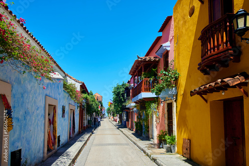 Empty street amidst colorful houses under blue sky photo