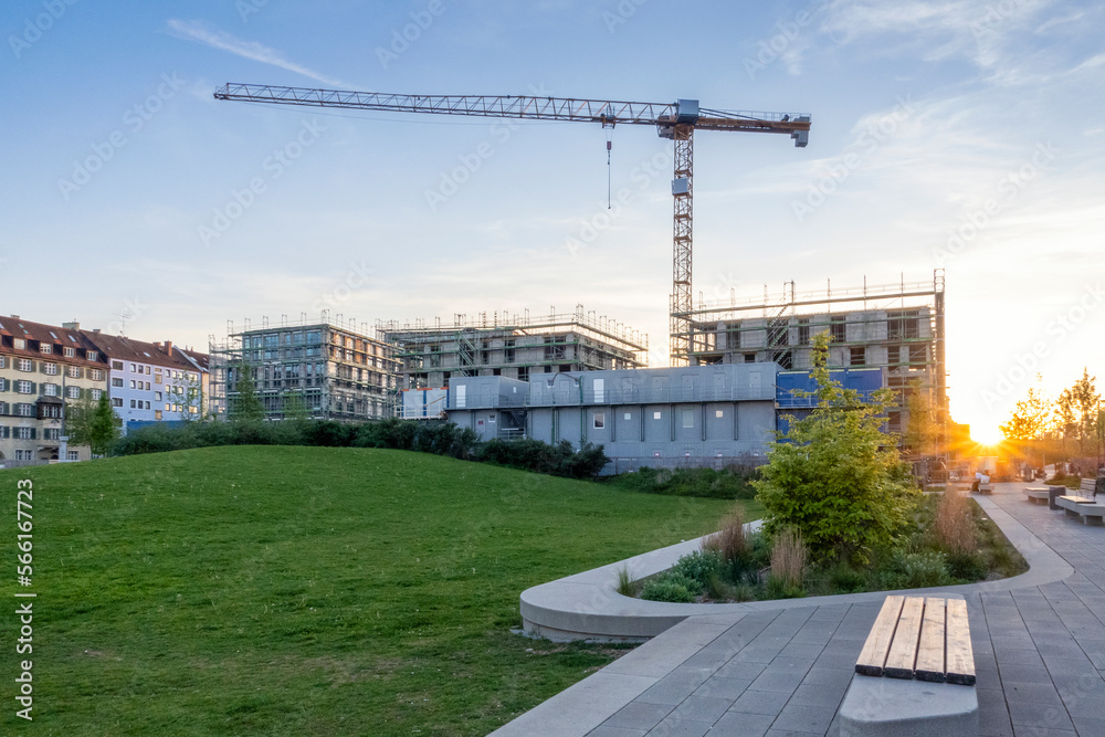 Germany, Bavaria, Munich, Construction site of modern apartment building at sunset Germany, Bavaria, Munich, Construction site of modern apartment building at sunset