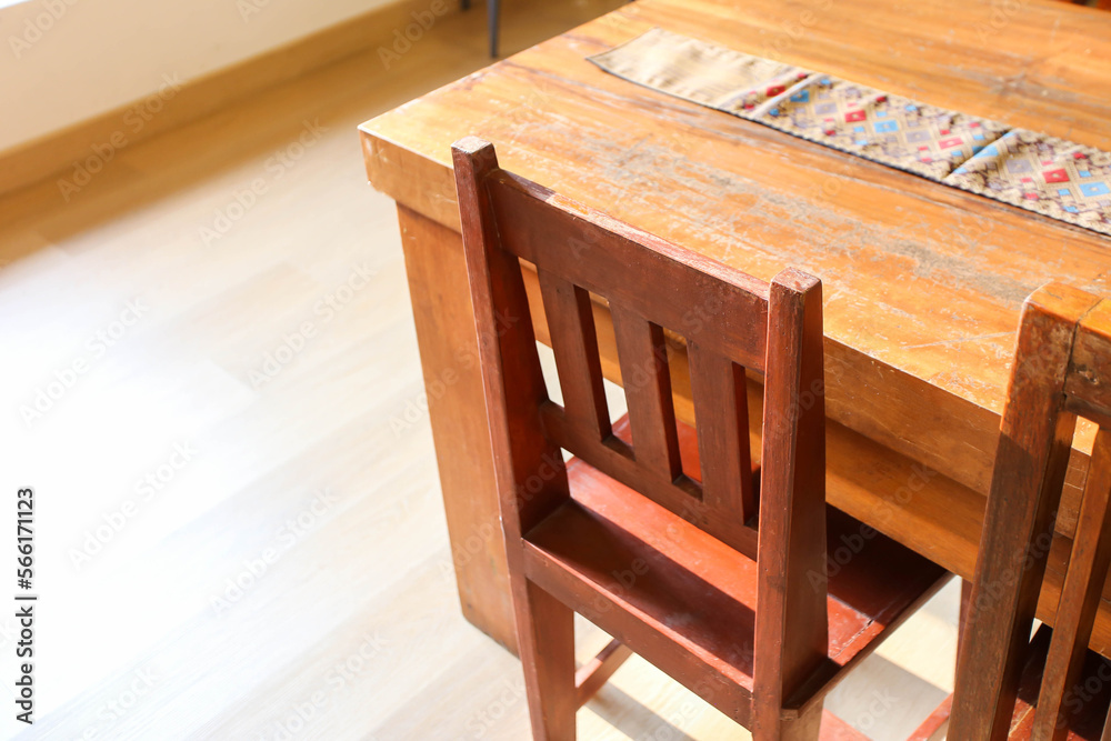 The wooden table and chairs near the window in cafe with sunlight The wooden table and chairs near the window in cafe with sunlight