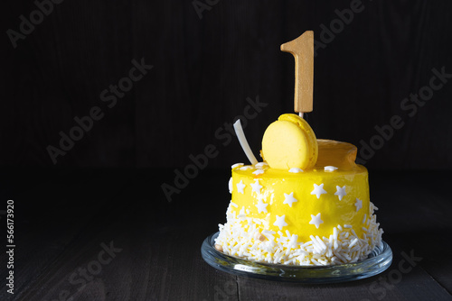 The number One on a yellow cake for an anniversary or birthday in a dark key. photo