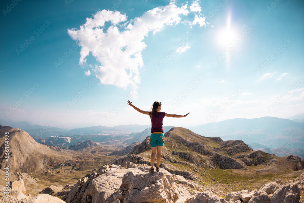 Obraz premium the traveler stands on the top of the mountain. the girl goes to the mountains.