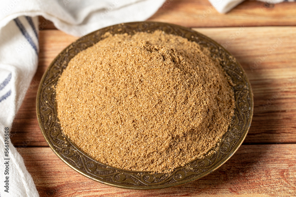 Powdered coriander spice. Coriander powder or dhaniya powder on wooden background. Dry spice concept. close up