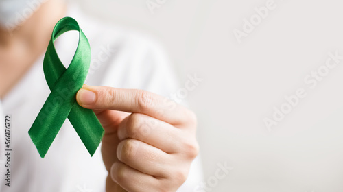 World lymphoma awareness day. A female doctor holds green ribbon. September 15. Liver, Gallbladders bile duct, kidney Cancer and Lymphoma Awareness month.
