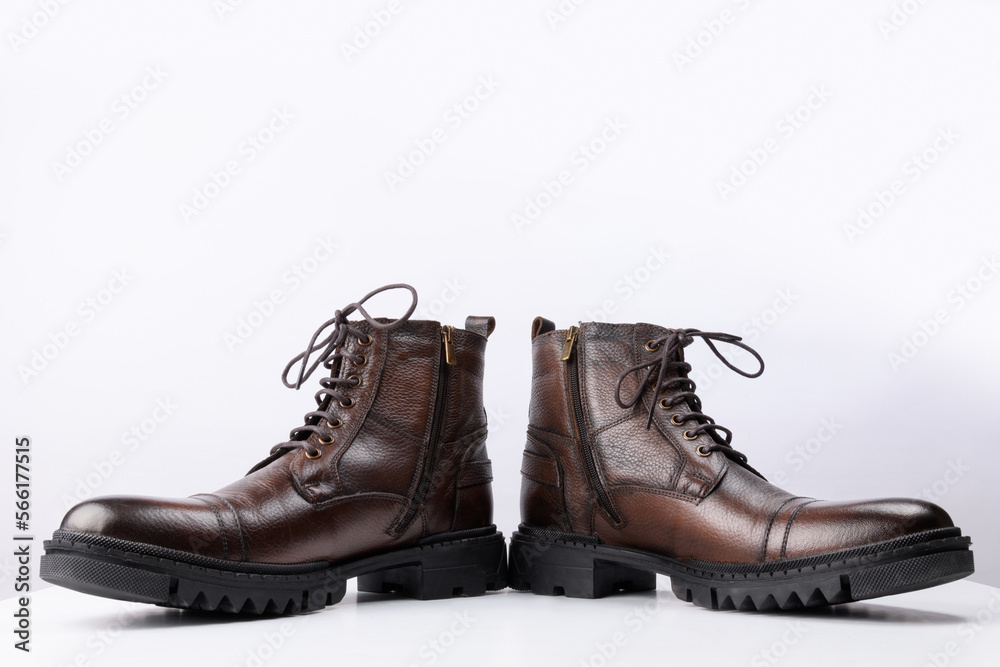 A pair of brown colored leather boots on a white background.