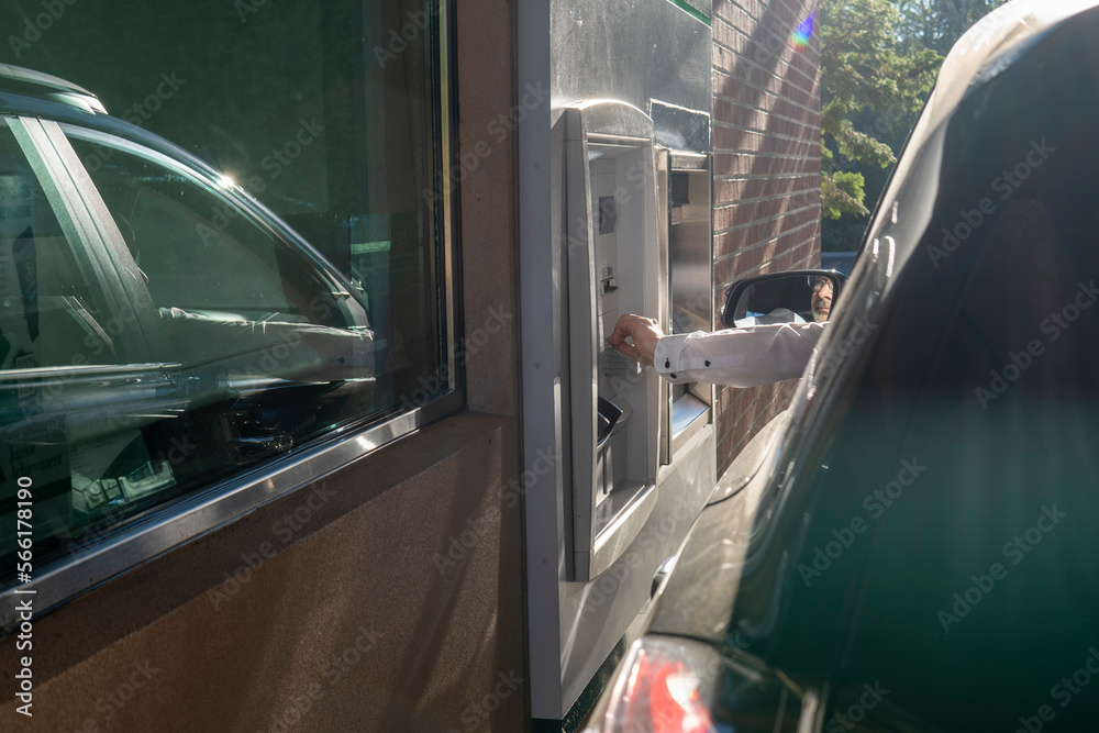 Man using - ATM drive through. Man's hand from the car with card near ATM. Money withdrawal