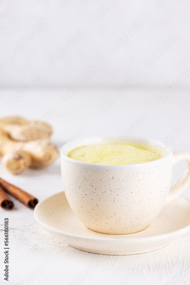 Golden milk with almond milk, ginger, turmeric and cinnamon in a mug, sugar and lactose free. Golden milk with almond milk, ginger, turmeric and cinnamon in a mug, sugar and lactose free.