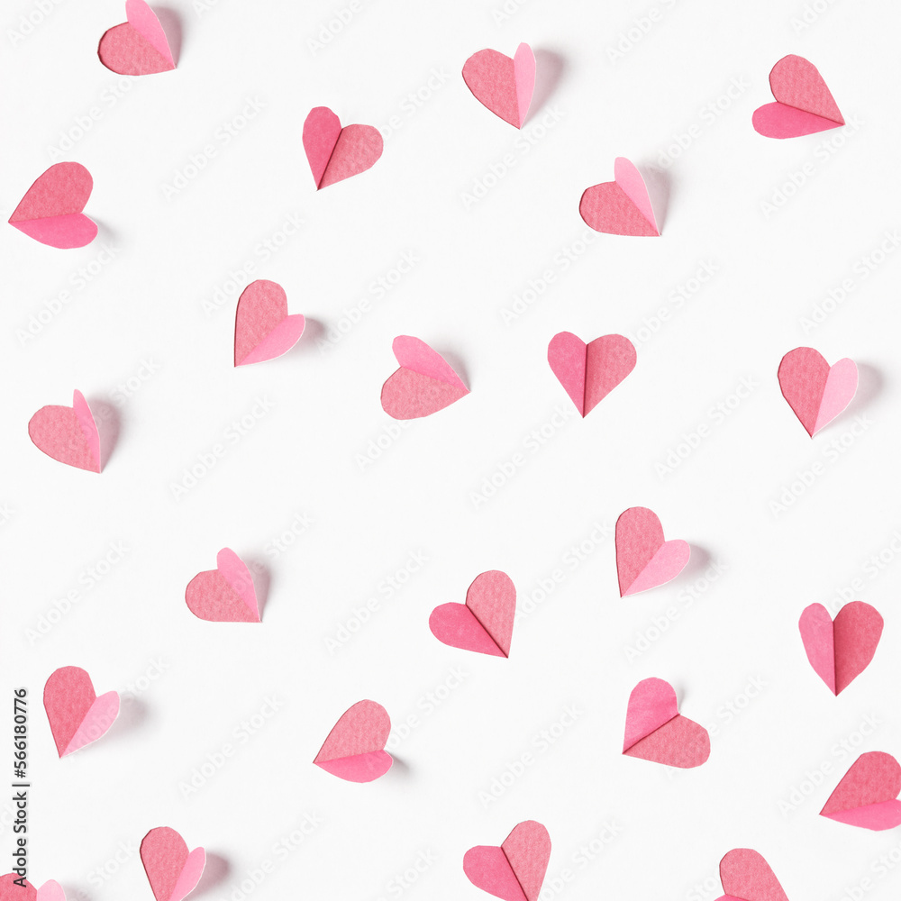 Pink hearts cut out from white paper. Festive background for valentine's day.