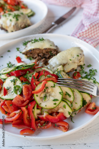 Low carb dinner or lunch with a fresh mediterranean salad and meatballs  or burger on plate