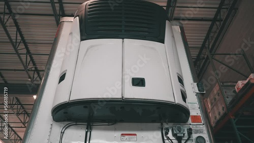 low angle of a front reefer trailer sitting in a repair shop of a truck and trailer maintnance building
