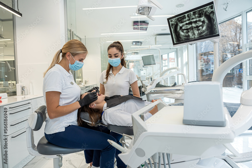 dentist with help of an assistant conducts a professional examination of patient's oral cavity. dentist with help of an assistant conducts a professional examination of patient's oral cavity.