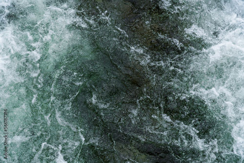 Close up of white water flowing down a river with melting water in Norway