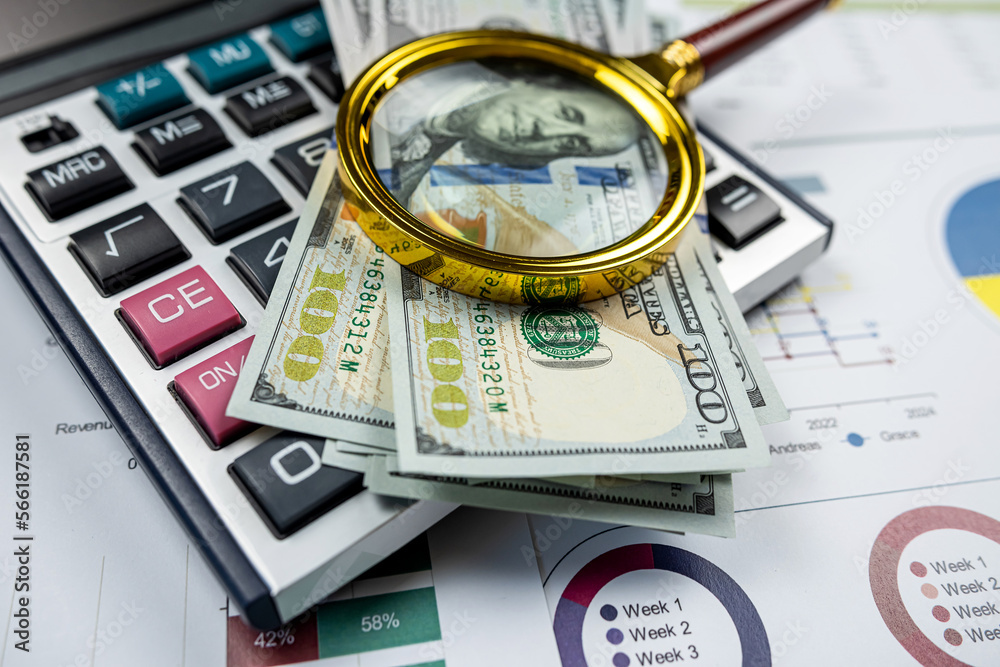 business graphs paper with dollar bills magnifying glass calculator and pen on office desk business graphs paper with dollar bills magnifying glass calculator and pen on office desk