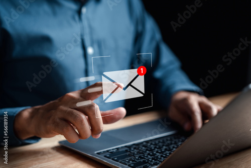 Businessman sending email by laptop computer to customer, business contact and communication, email icon, email marketing concept, send e-mail or newsletter, online working internet network. photo