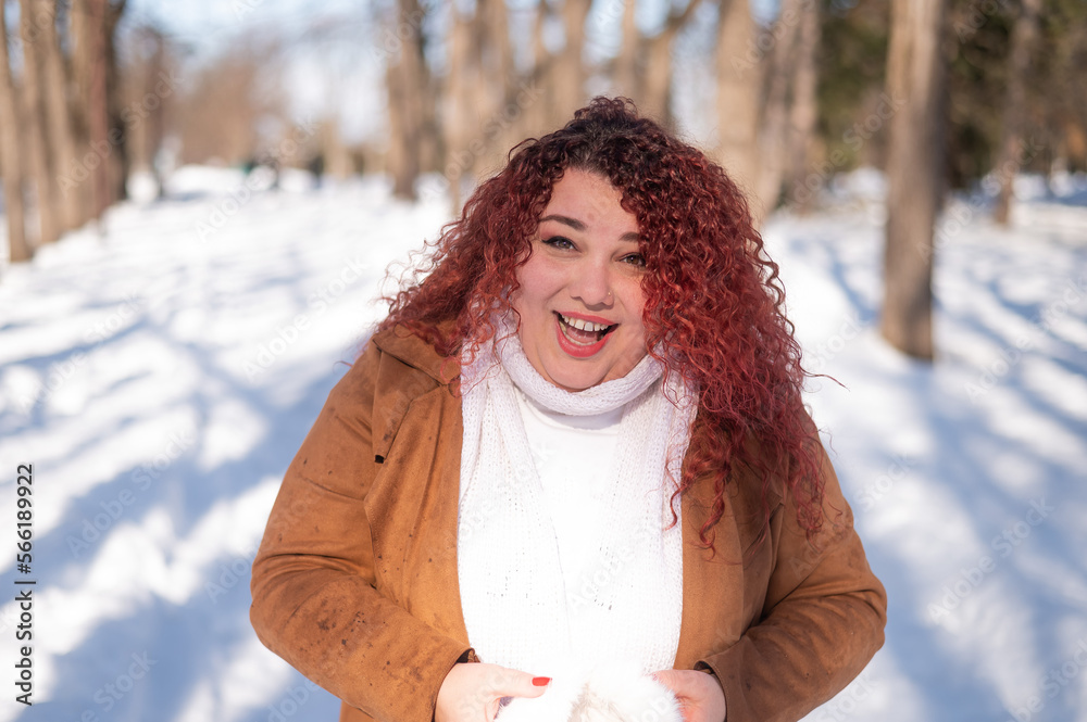 Cheerful fat caucasian woman in fur headphones outdoors. Cheerful fat caucasian woman in fur headphones outdoors.