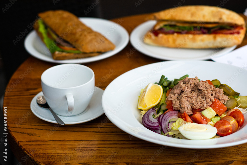 Full table of delicious and different dishes in cafe with cup of coffee in white dinnerware.