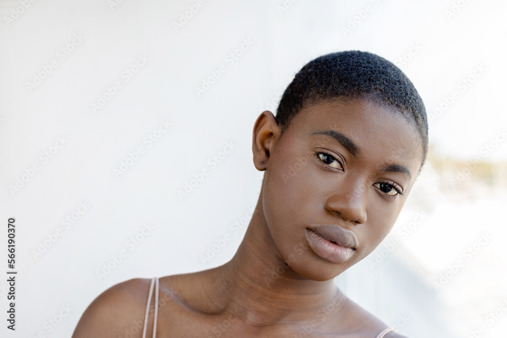 Serious Black woman standing with head tilted to the side