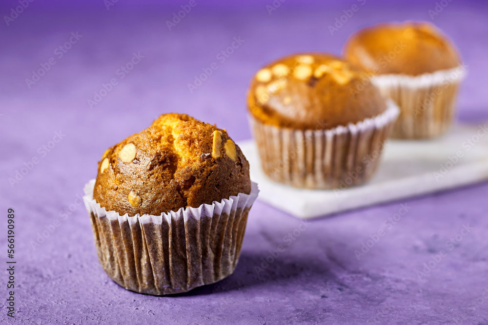 Vanilla Caramel Nuts Muffins In Paper Cups On purple background Vanilla Caramel Nuts Muffins In Paper Cups On purple background