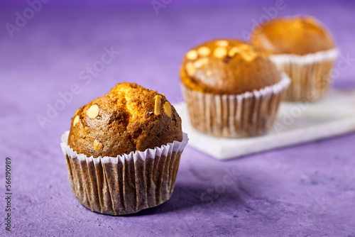 Vanilla Caramel Nuts Muffins In Paper Cups On purple background
