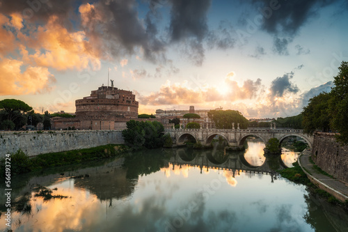 Fiery clouds at sunrise above medieval St. Angelo castle and the bridge over Tiber river in Rome, Italy.
