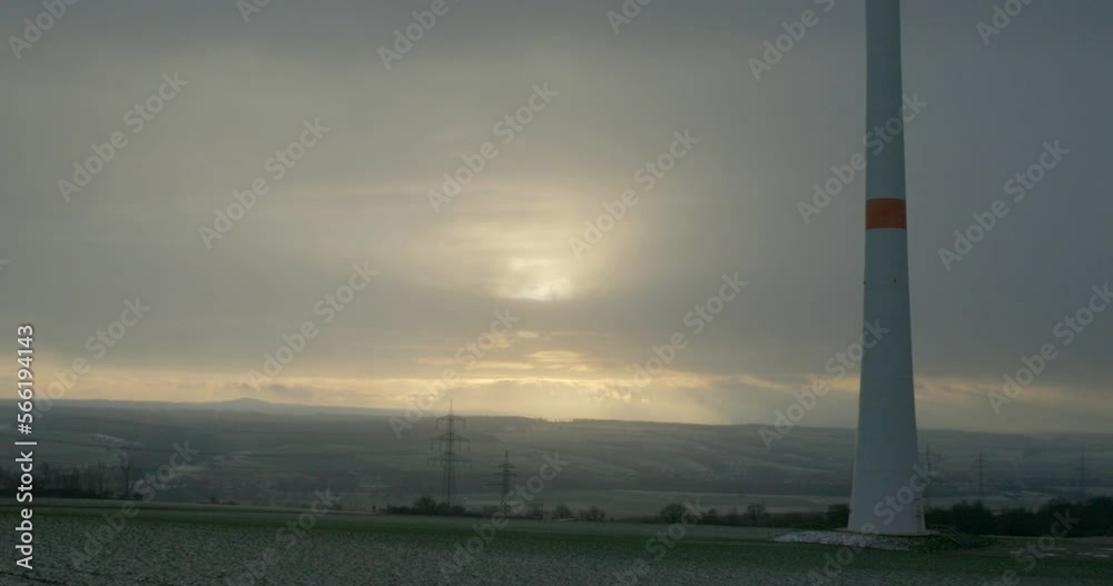 Trendelburg, Germany - 01 19 2023: North Hessian landscape with a valley and the Reinhardswald in the background. In the foreground is the tower of a wind turbine. Trendelburg, Germany - 01 19 2023: North Hessian landscape with a valley and the Reinhardswald in the background. In the foreground is the tower of a wind turbine.