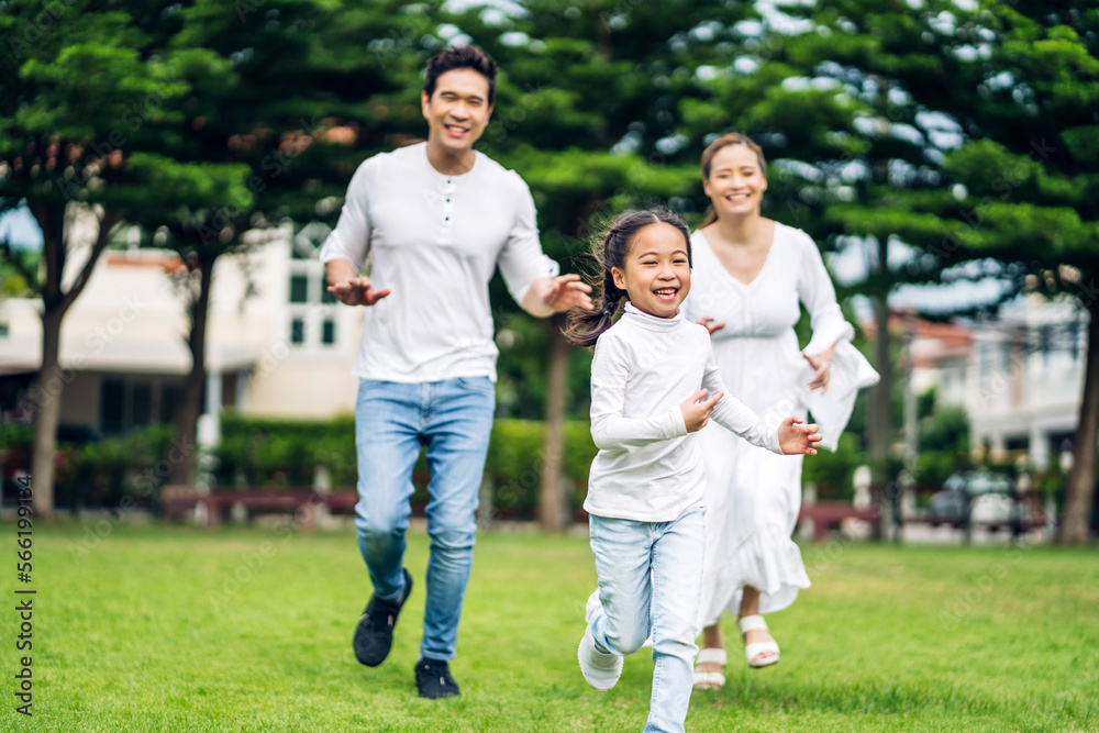 Portrait of enjoy happy love asian family father and mother holding cute little asian girl child smiling playing and having fun moments good time in summer park at home.