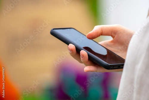 Close-up of a girl's hand holding a smartphone on a blurred background