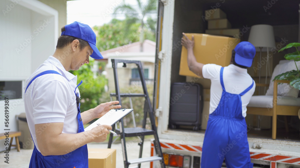 Team of employee workers with a truck car moving house for customers, delivering boxes with uniform.Vehicle transportation. Shipping and packaging business occupation service company. People lifestyle Team of employee workers with a truck car moving house for customers, delivering boxes with uniform.Vehicle transportation. Shipping and packaging business occupation service company. People lifestyle