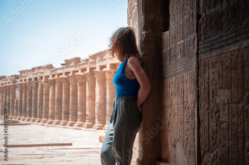 Young woman watching from behind the Philae temple in Egypt. photo