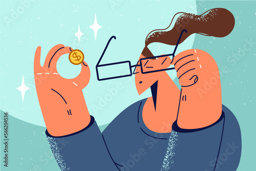 Woman in glasses look at golden coin