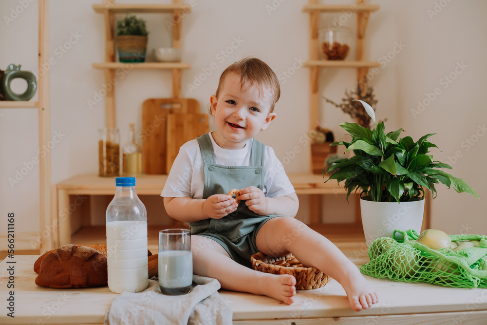 a happy little girl is sitting in the kitchen drinking milk. Plastic Milk Bottle mockup a happy little girl is sitting in the kitchen drinking milk. Plastic Milk Bottle mockup