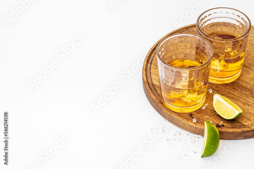 Glass of whiskey with lime and ice. Strong alcohol background