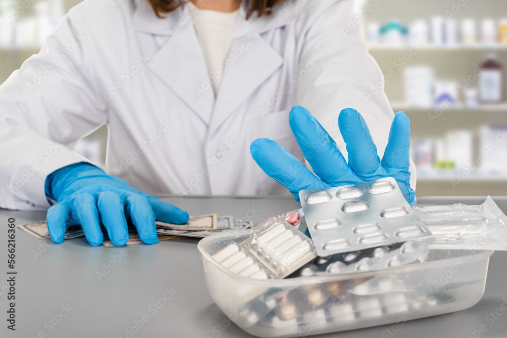 Close-up of a female pharmacist pushing back medicines in a pharmacy Close-up of a female pharmacist pushing back medicines in a pharmacy