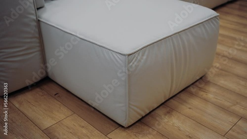 Slow shot to a piece of white sofa on a brown floor. 4k video.