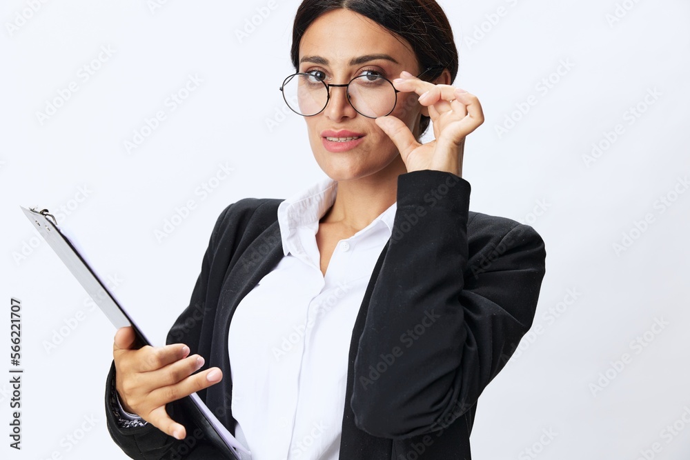 Business woman with a folder of documents in her hands in a black business suit and glasses shows signals gestures and emotions on a white background, work freelancer online training Business woman with a folder of documents in her hands in a black business suit and glasses shows signals gestures and emotions on a white background, work freelancer online training