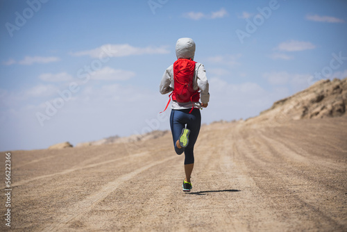 Fitness woman trail runner cross country running  on desert