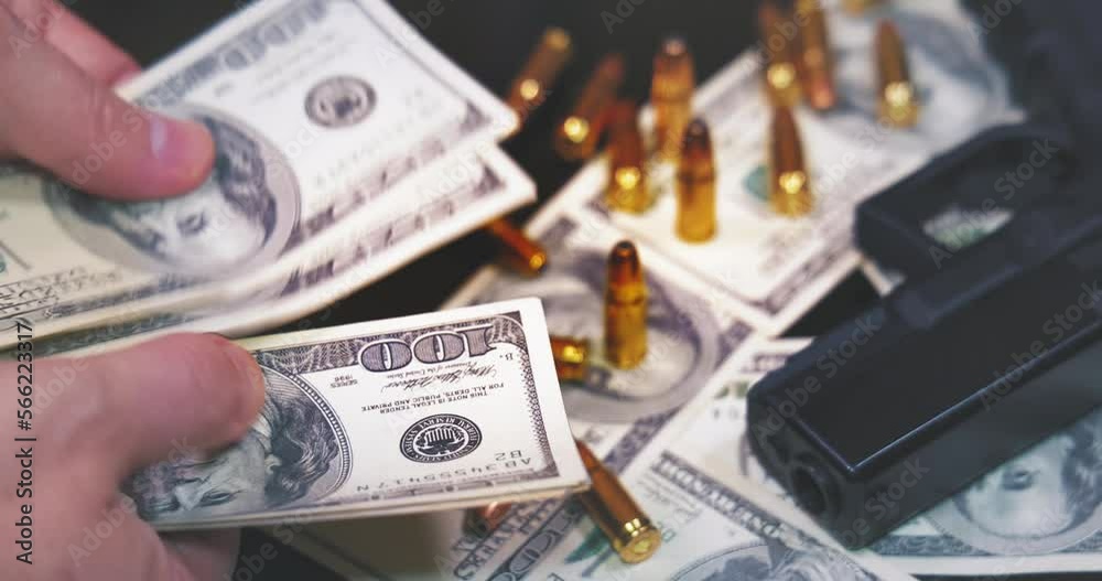 Counting dollar bills, gun and bullets on dollar banknotes background. Criminal money. Black money and protection, mafia and corruption concept, slow motion Counting dollar bills, gun and bullets on dollar banknotes background. Criminal money. Black money and protection, mafia and corruption concept, slow motion
