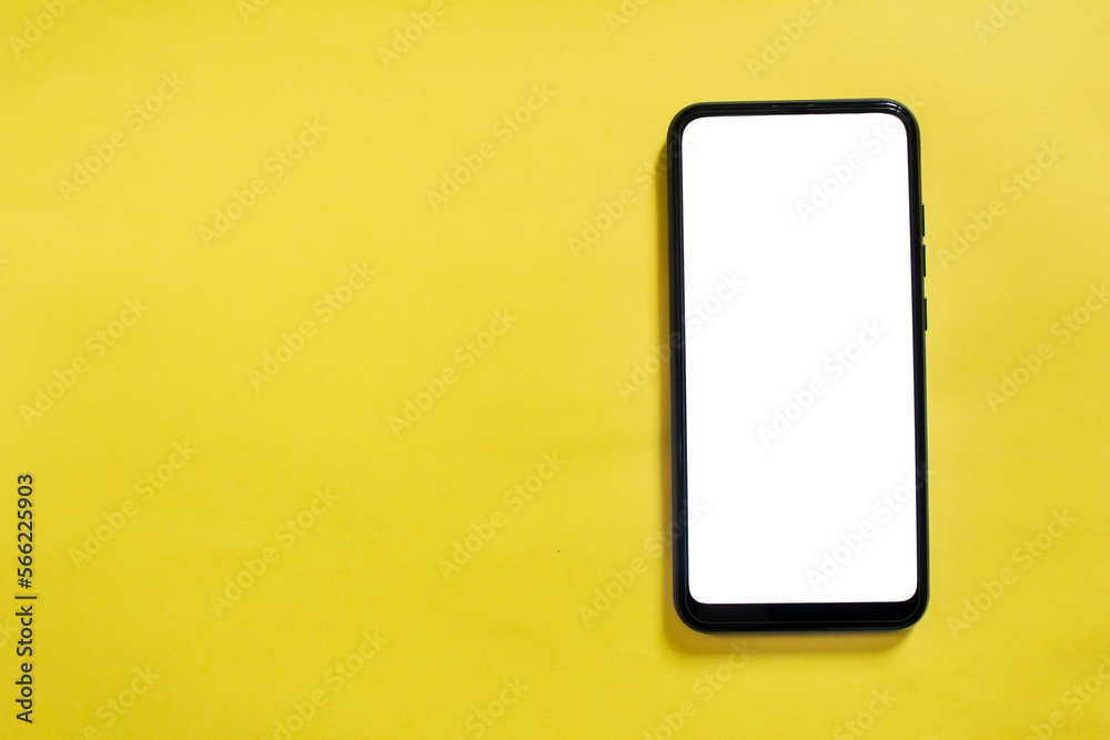 Mockup image of phone. Top view of smartphone on yellow background with blank white screen. Copy space. Mockup image of phone. Top view of smartphone on yellow background with blank white screen. Copy space.
