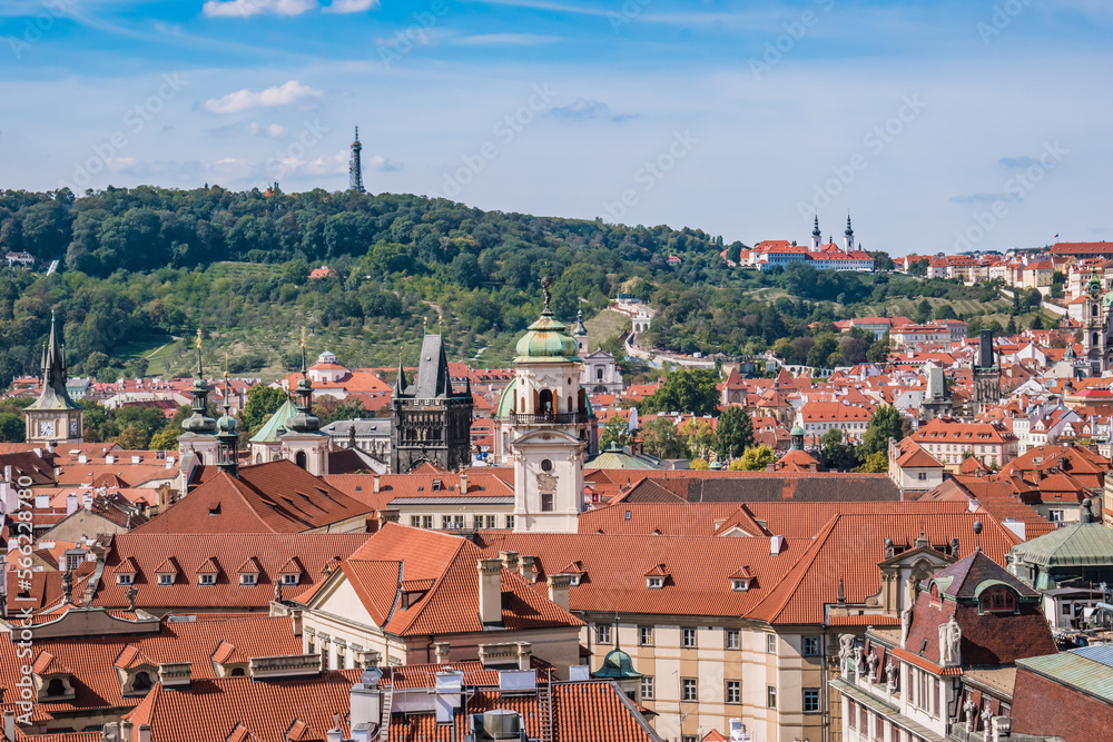 Roofs and towers of Prague monuments and churches with hill and tower of Petrin in horizon, Czechia