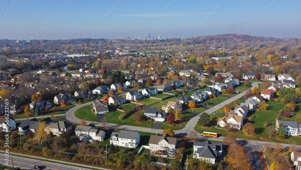 Aerial view row of two-story houses in upscale residential neighborhood with downtown Rochester skylines and Pinnacle Hill background in Rochester, Upstate New York