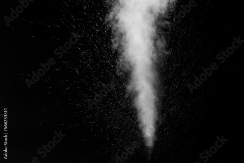 A jet of white water vapor with splashes of water from the humidifier Isolated on a black background.