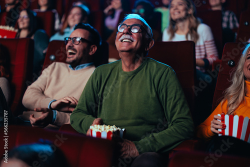 фотографія Cheerful senior watching movie in theater.