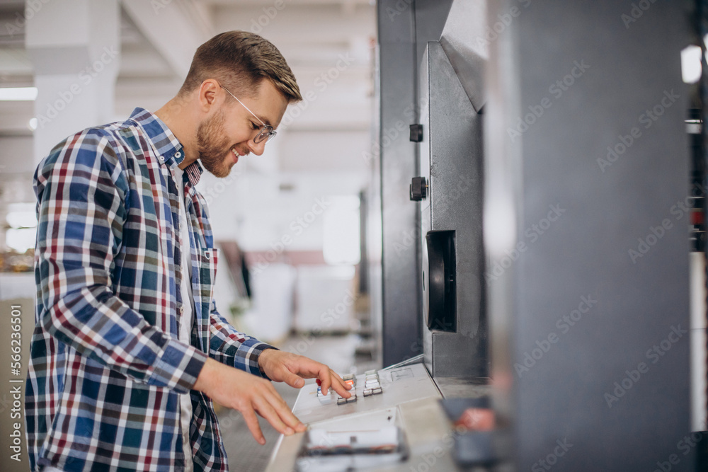 Man working in printing house with paper and paints