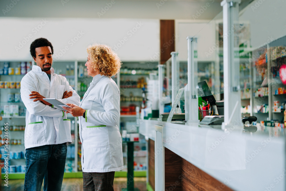 Fototapeta premium Pharmacists working together with digital tablet.