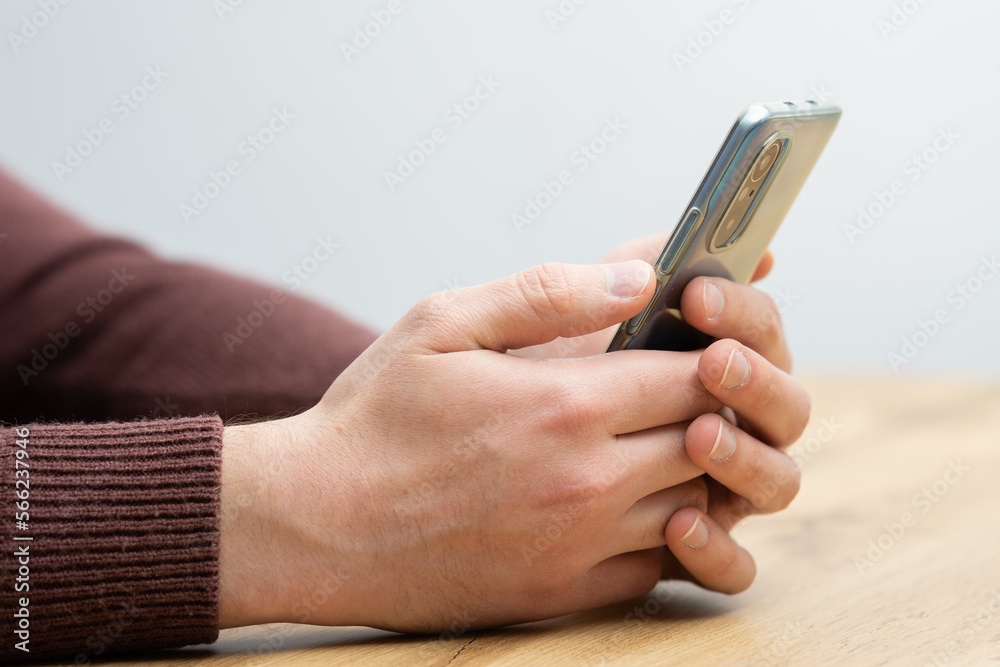 Fototapeta premium Man hands holding smartphone. Man using smartphone and pointing on the screen with one finger