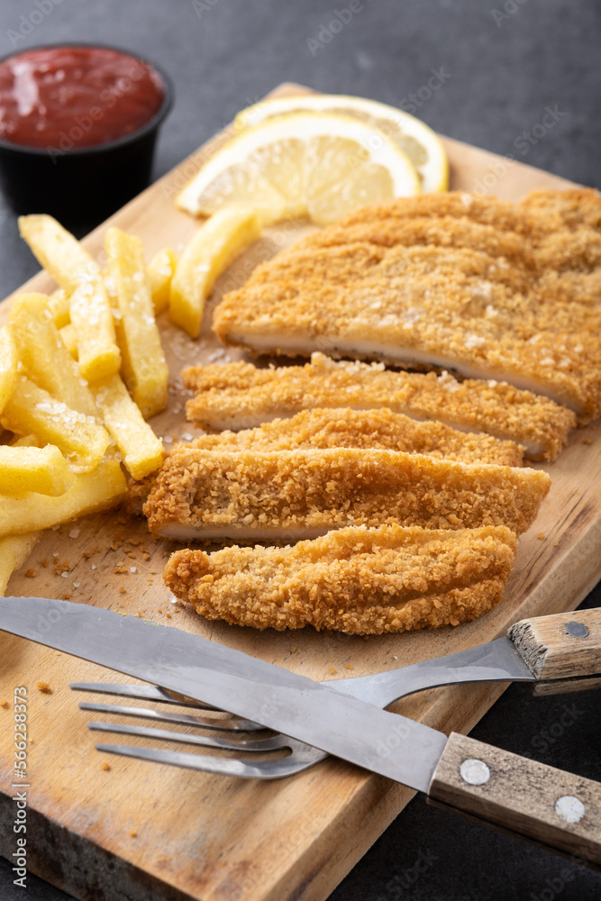 Wiener schnitzel with fried potatoes on black background Wiener schnitzel with fried potatoes on black background