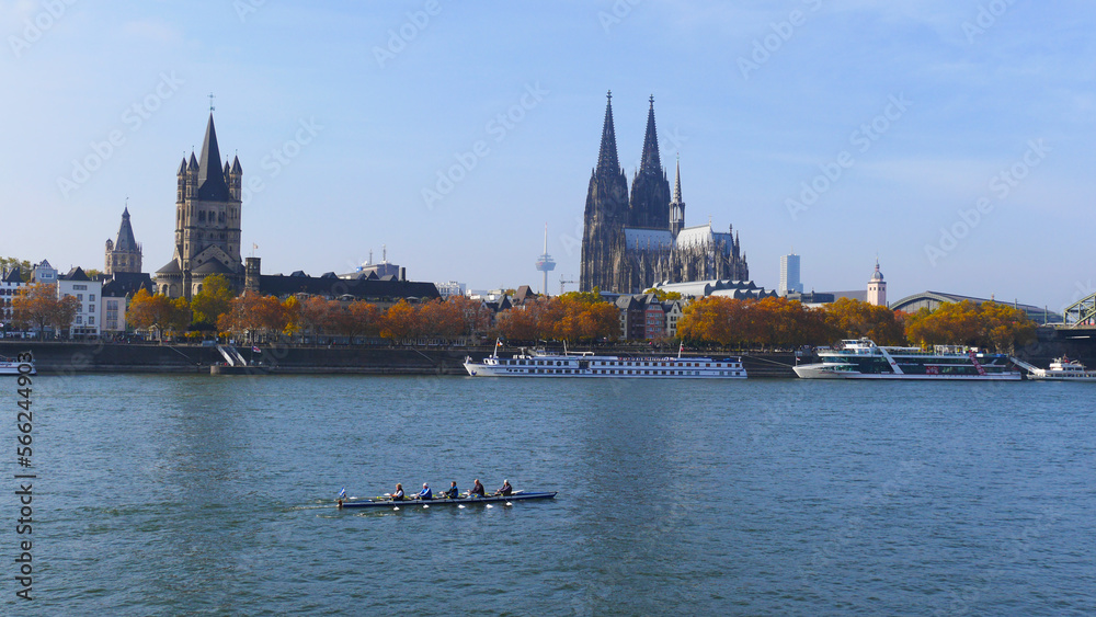 A view of Cologne cathedral with a rowing boat in the river Rhine on a sunny day with blue sky | landmark, sightseeing, watersports, rowing Germany